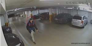Zdjęcie poglądowe, przedstawiające mężczyznę, który idzie w podziemnym parkingu samochodowym.
