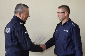Zdjęcie poglądowe, przedstawiające Komendanta Wojewódzkiego Policji w Gdańsku jak gratuluje i wręcza dyplom najlepszemu dyżurnemu z pomorza.