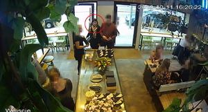 Zdjęcie poglądowe, przedstawiające kobietę, która podejrzewana jest o przywłaszczenie portfela. Kobieta z mężczyzną stoją przy kelnerce w restauracji.