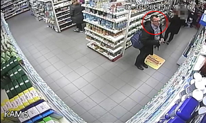 Zdjęcie poglądowe, przedstawiające mężczyznę podejrzewanego o kradzież perfum. Mężczyzna ma plecak na sobie. Stoi przed regałami i patrzy na asortyment.