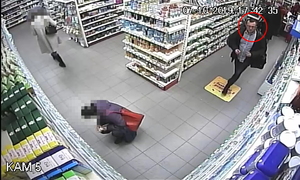 Zdjęcie poglądowe, przedstawiające mężczyznę podejrzewanego o kradzież perfum. Mężczyzna chodzi po sklepie i obserwuje asortyment na półkach.
