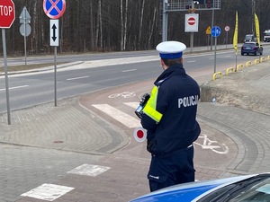 Zdjęcie przedstawiające policjanta przy drodze rowerowej.
