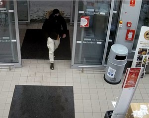 Zdjęcie przedstawiające mężczyznę, który wchodzi do sklepu.