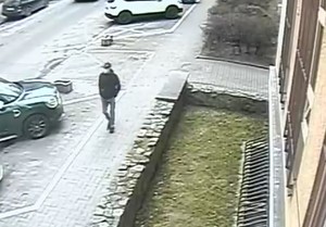 Zdjęcie przedstawiające mężczyznę, który idzie chodnikiem wzdłuż budynku.