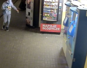 Zdjęcie przedstawiające mężczyznę idącego tunelem SKM obok automatu ze słodyczami