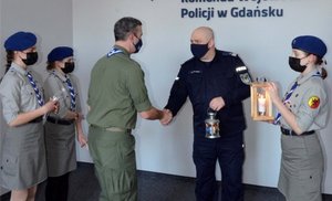 Zdjęcie przedstawiające przekazanie na ręce Komendanta Wojewódzkiego Policji w Gdańsku Betlejemskiego Światełka Pokoju