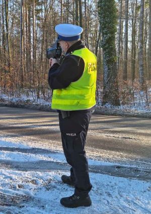 Zdjęcie przedstawiające policjanta podczas pomiaru prędkości