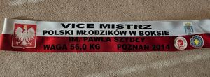 Zdjęcie przedstawiające szarfę z napisem Vice Mistrz Polski Młodzików w Boksie