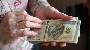 Zdjęcie poglądowe, przedstawiające banknoty w dłoniach. Na zdjęciu widać banknot o nominale 200 zł.