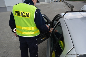 Zdjęcie poglądowe, przedstawiające kontrolę drogową, podczas której policjant ruchu drogowego sprawdza kierującemu trzeźwość.