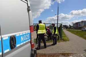 Zdjęcie poglądowe, przedstawiające dwóch policjantów rozmawiających z rowerzystą.