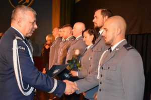 Zdjęcie poglądowe, przedstawiające Komendanta Wojewódzkiego Policji w Gdańsku, który wręcza gdyńskim policjantom akty mianowania na wyższe stopnie służbowe.