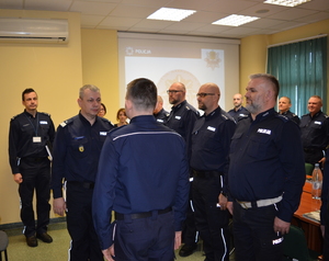 Zdjęcie poglądowe, przedstawiające Komendanta Wojewódzkiego Policji w Gdańsku, Komendanta Miejskiego Policji w Gdyni oraz innych policjantów garnizonu gdyńskiego. Funkcjonariusze spotkali się na rocznej odprawie.