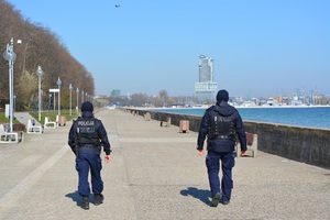 Zdjęcie przedstawiające dwóch policjantów, którzy patrolują Bulwar Nadmorski.