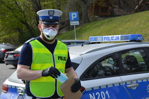 Policjant w maseczce podczas prowadzonych działań ZKM - COVID