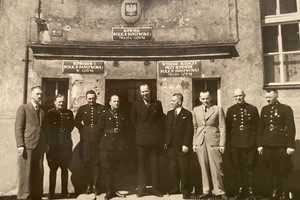 Zdjęcie przedstawiające przedwojennych policjantów, ustawionych do wspólnej fotografii pod Komisariatem Policji.