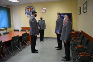 Zdjęcie przedstawiające Komendanta Miejskiego Policji w Gdyni podczas wręczania rozkazu nowemu Zastępcy Komendanta Komisariatu Policji w Gdyni - Oksywiu. Na zdjęciu jest również Zastępca Komendanta Miejskiego Policji w Gdyni oraz Naczelnik Wydziału Kadr i Szkolenia.