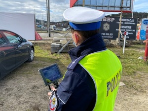 Zdjęcie przedstawiające policjanta podczas sterowania dronem.