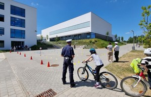 Zdjęcie przedstawiające policjanta podczas przeprowadzania egzaminu na kartę rowerową