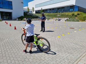 Zdjęcie przedstawiające policjanta podczas przeprowadzania egzaminu na kartę rowerową