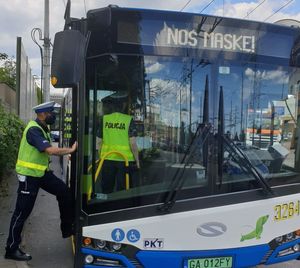 Zdjęcie przedstawiające policjantów kontrolujących autobus