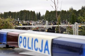 Zdjęcie poglądowe, przedstawiające napis Policja na tle cmentarza