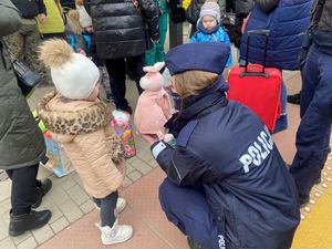 Zdjęcie przedstawiające policjantów pomagających uchodźcom z Ukrainy