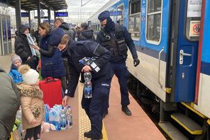 Zdjęcie przedstawiające policjantów pomagających uchodźcom z Ukrainy