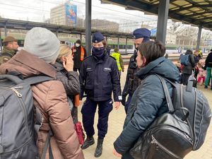 Zdjęcie przedstawiające policjantów pomagających uchodźcom z Ukrainy