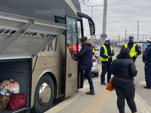 Zdjęcie przedstawiające policjantów pomagających uchodźcom z Ukrainy