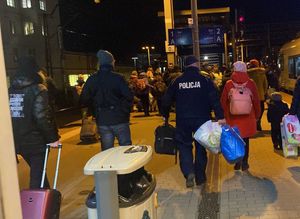 Zdjęcie przedstawiające policjantów pomagających uchodźcom z Ukrainy