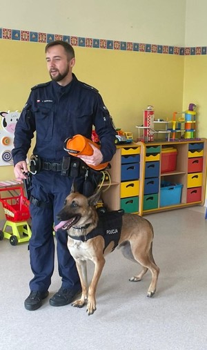 Zdjęcie przedstawiające policjanta z psem służbowym