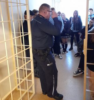 Zdjęcie przedstawiające dzielnicowego z Komisariatu Policji w Gdyni - Oksywiu, oraz uczniów z klasy o profilu mundurowym