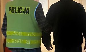 Zdjęcie policjanta prowadzącego zatrzymanego mężczyznę