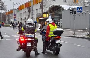 Zdjęcie przedstawiające policjanta na motocyklu oraz mężczyznę przebranego za Mikołaja na motocyklu