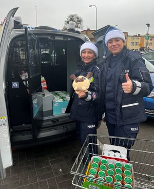 Zdjęcie przedstawiające policjantki podczas pakowania do radiowozu darów dla podopiecznych dziecięcego hospicjum