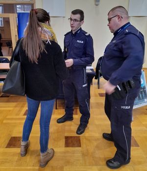 Zdjęcie z targów pracy służb mundurowych, przedstawiające policjantów z kandydatką do Policji