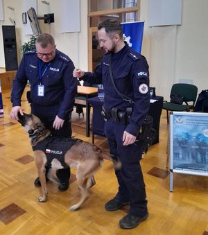 Zdjęcie z targów pracy służb mundurowych, przedstawiające policjantów z psem służbowym