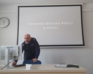 Zdjęcie przedstawiające Naczelnika Wydziału Kadr i Szkolenia Komendy Miejskiej Policji w Gdyni podczas prelekcji