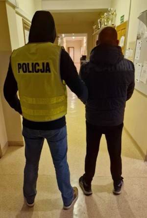 Zdjęcie przedstawiające policjanta z zatrzymanym mężczyzną