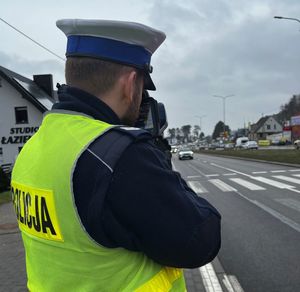 Zdjęcie przedstawiające policjanta podczas pomiaru prędkości