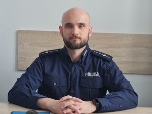 Zdjęcie przedstawiające policjanta, który pisze książki dla dzieci