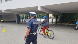 Zdjęcie przedstawiające policjanta podczas przeprowadzania egzaminu na kartę rowerową