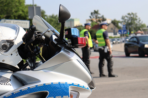 Zdjęcie przedstawiajęce policjantów na tle motocykla, podczas zabezpieczenia