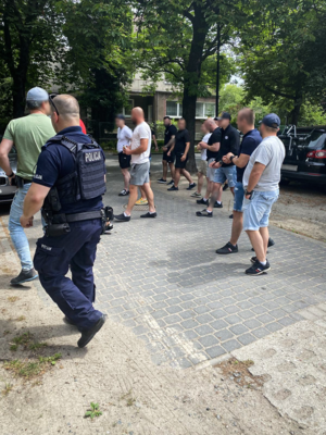 Zdjęcie przedstawiające grupę mężczyzn oraz policjanta