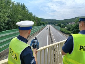 Zdjęcie przedstawiające policjantów drogówki podczas pomiaru prędkości