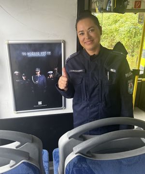 Zdjęcie przedstawiające policjantkę na tle plakatu promującego zawód policjanta