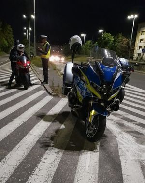 Zdjęcie przedstawiające policjanta, który przeprowadza kontrolę motocyklisty