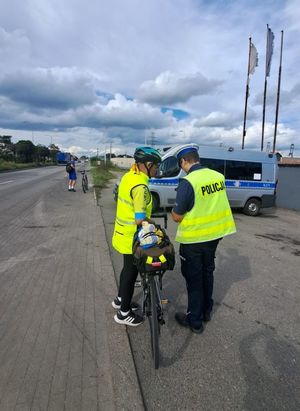 Zdjęcie przedstawiające policjanta podczas kontroli rowerzystki