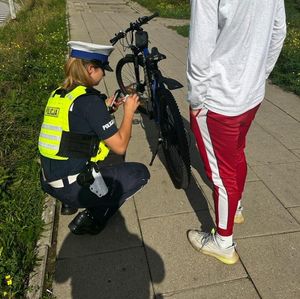 Zdjęcie przedstawiające policjantkę podczas kontroli rowerzysty